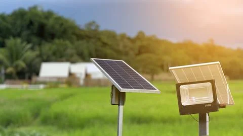 Solar panels set against a backdrop of resident, trees and a vibrant blue s.. Stock Photos