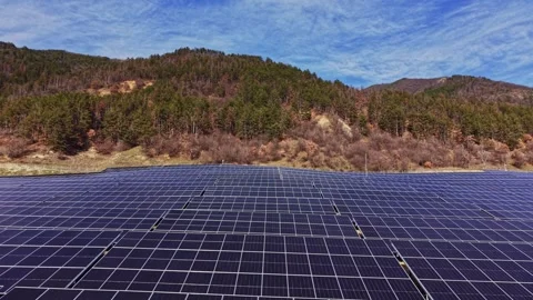 Solar panels set in green hills during bright daylight hours 動画素材 334033116