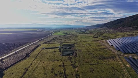 Solar panels spread across fields in a rural area near a highway 스톡 동영상 334034751
