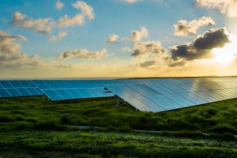 Solar panels at sunrise with dramatic cloudy sky in Normandy, France. Modern Stock Photos