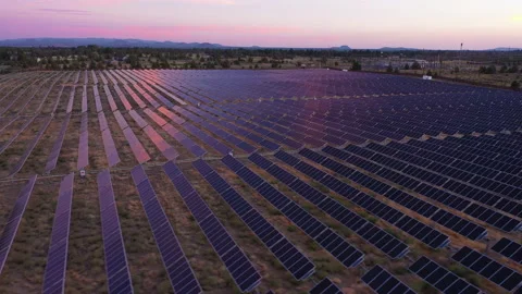 Solar panels at twilight, tracking and panning to the left, pink and purple sky Stock Footage 160890207