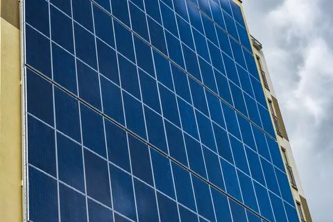 Solar panels on the wall of a multi-storey building on storm clouds backgroun Fotos de archivo