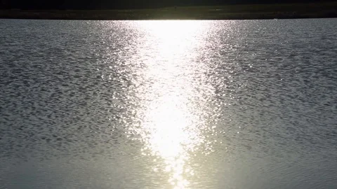 Solar path reflecting on the waves during sunrise Stock Footage 128959511