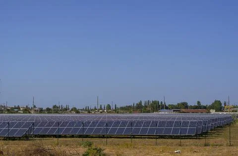 A solar power plant against the backdrop of a small residential community. Stock Photos