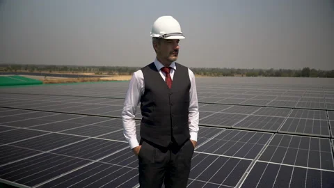 Solar power plant engineer in hard hat inspection photovoltaic on roof top at Stock Footage 154284442