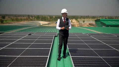 Solar power plant engineer in hard hat walking to inspection photovoltaic on Stock Footage 154285407