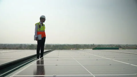 Solar power plant engineer manager in hardhat inspection  photovoltaic on roo Stock Footage 154287236