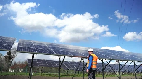 Solar power plant worker in uniform fixing panels with a drill. Stock Footage 168178486