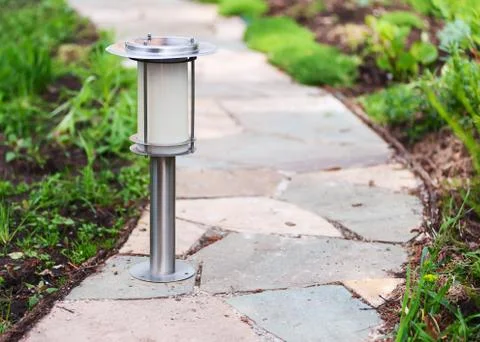 Solar-powered lamp on garden path. Stock Photos