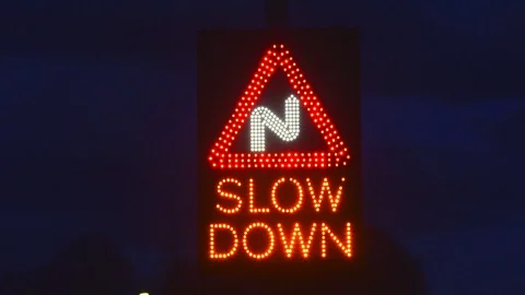 Solar powered traffic triggered slow down roadsign before sharp bends uk Stock Footage 88395214