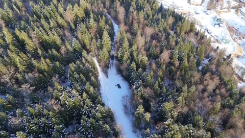 Solar powered vehicle on snowy forest road, drone tilt up reveal in Parc 動画素材 336124701