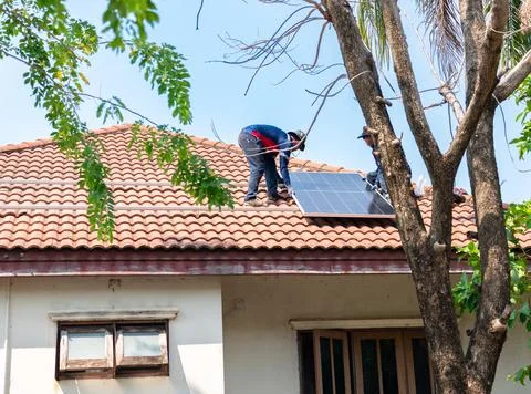 Solar technicians installing a photovoltaic panel on a residential terracot.. Foto stock