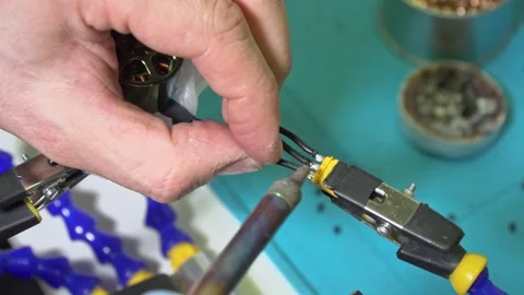 Soldering black motor wires to XT30 connector for drone assembly Stock Footage 331482996