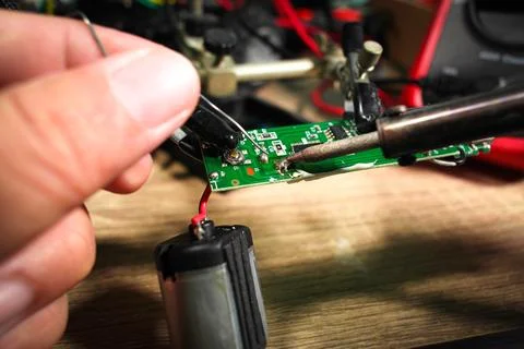Soldering electronic boards using an electric soldering iron and soldering lead Foto stock