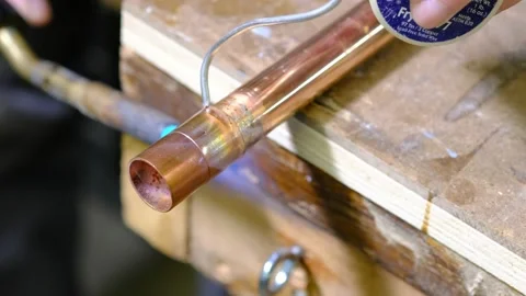 Soldering a fitting onto a copper pipe Stock Footage