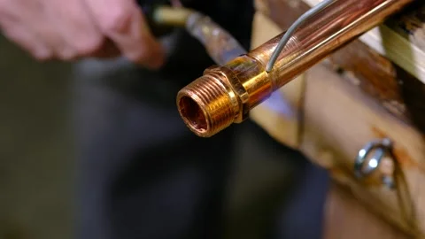 Soldering a fitting onto a copper pipe with a torch Stock Footage 139367681