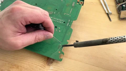 Soldering a micro chip processor with iron tool Stock Footage 257061825
