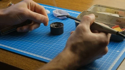 Soldering small parts by hand using good old methods. 4k Stockbeeldmateriaal 102204285