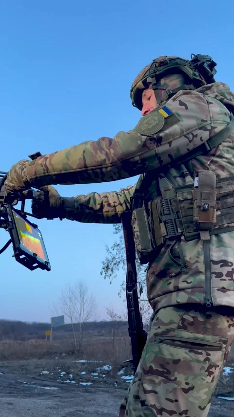 A soldier aims at a machine gun, looking at a thermal imager, aimed at a target Stock Footage 296801918