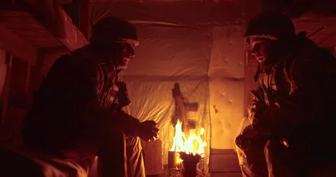 A soldier and a chaplain sit opposite each other in a dark dugout Stock Footage 263296480