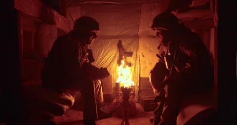 A soldier and a chaplain sit opposite each other in a dark dugout Stock Footage 263296669