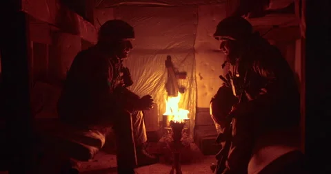 A soldier and a chaplain sit opposite each other in a dark dugout Stock Footage 263296676