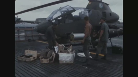 Soldier and instructor pilot load 40mm grenades and mini guns on AH-1G - 1969 Stock Footage 96143694
