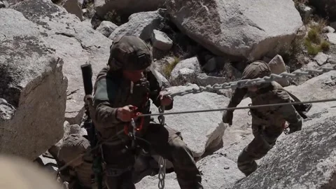 Soldier ascending rock face using rope and clamp Stock Footage 255117739