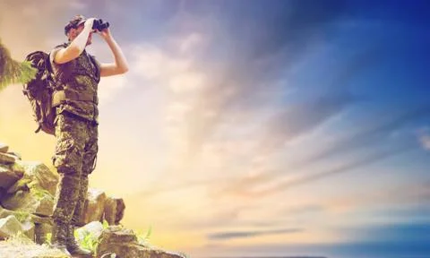 Soldier with backpack looking to binocular 写真素材