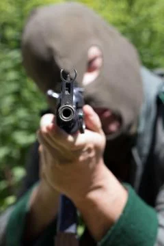 Soldier with balaclava pointing with automatic machine Foto stock