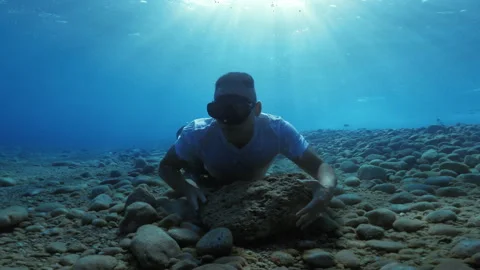 Soldier with big stone underwater Stock Footage 256421953