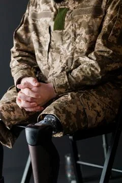 Soldier with Bionic Leg Prosthesis Seated in Camouflaged Uniform Stock Photos