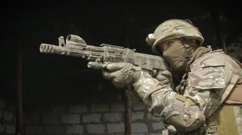 Soldier in the burned a room aiming a machine gun and looking through binoculars Video stock 62761029