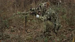 Camouflaged woman sniper in ghillie suit posing with rifle in foggy night.  Special Weapons and Woman Concept Stock Photo - Alamy