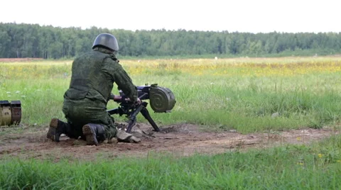 Soldier in camouflage uniforms fires automatic grenade launcher Stock Footage 65768229