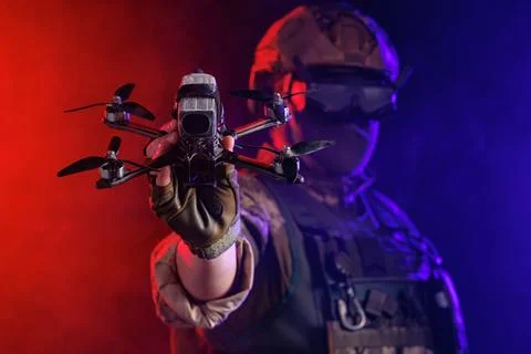 A soldier is depicted holding a drone while wearing stealth gear for milita.. Stock Photos