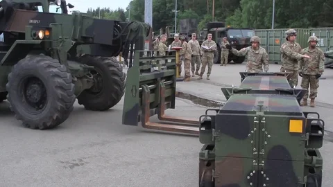 Soldier directing telescopic handler operator loading patriot missile Stock Footage 90120746