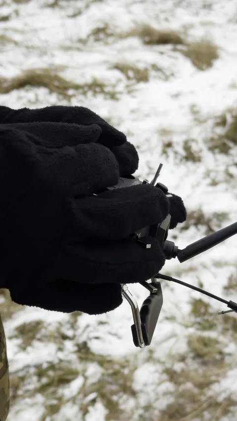 Soldier directs UAV using special remote device standing on battlefield Stock Footage 323844532
