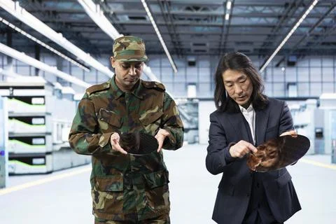 Soldier evaluates microchip development with microelectronics facility manager Stock Photos