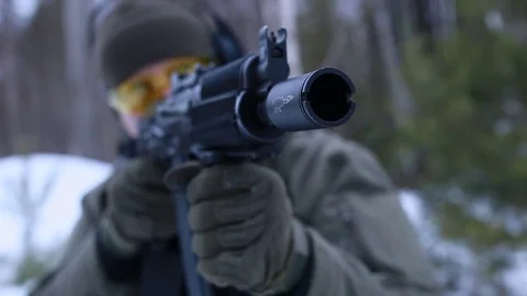 Soldier fires from AK automatic weapons in the winter forest Stock Footage 83176128