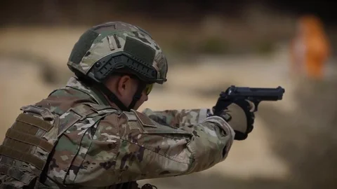 Soldier fires automatic handgun in slow motion 스톡 동영상 114017993