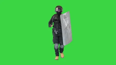 Soldier in full uniform with armor, baton, protective shield running on a Green Stock-Footage 148405573