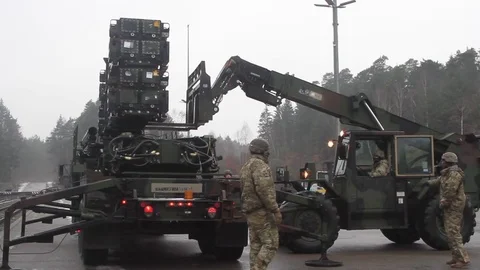 Soldier guiding telescopic handler unloading Patriot missile from trailer Stock Footage 102707670