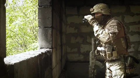 Soldier with a gun to the window and looking through binoculars Video stock 62761034