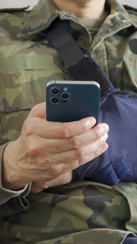 Soldier hand with broken arm wearing sling using phone Vídeos de archivo 337033481