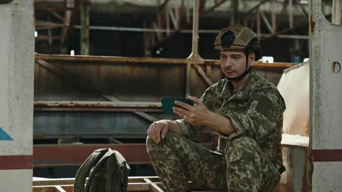 Soldier having video call on mobile among destroyed plant Video stock 201269592