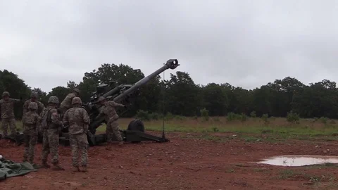 Soldier holds trigger cable on M777A2 Howitzer ready to fire Stock Footage 93078140