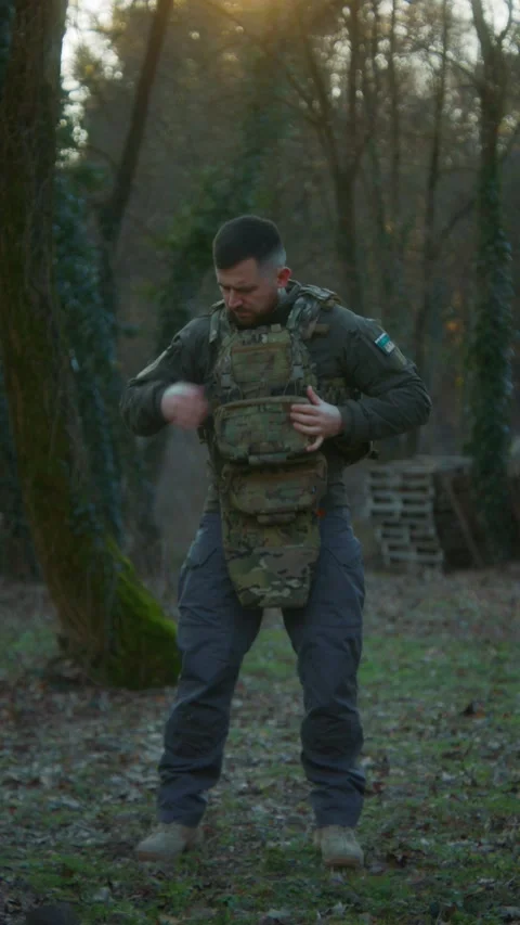 Soldier Inspecting and Putting On Plate Carrier with Tactical Pouches Stock Footage 337829800