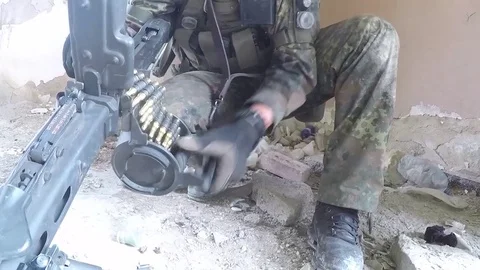 Soldier loading ammunition belt into machine gun 動画素材 93390274