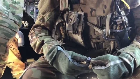 Soldier loading cartridges into machine gun belt onboard CH-47 Chinook Video stock 98029095